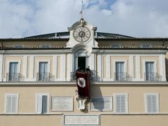 Spouštění tapisérie z okna papežovi letní rezidence v Castel Gandolfo.