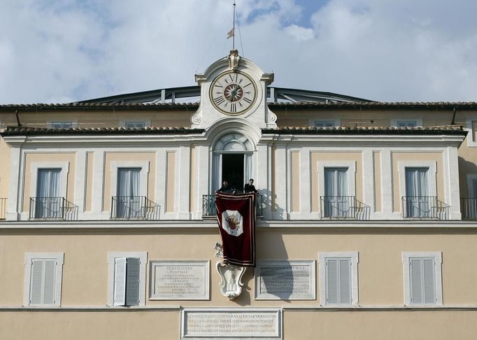 Spouštění tapisérie z okna papežovi letní rezidence v Castel Gandolfo.