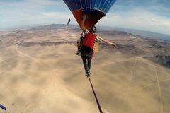VIDEO Adrenalin v oblacích. Muž přešel po laně mezi balony