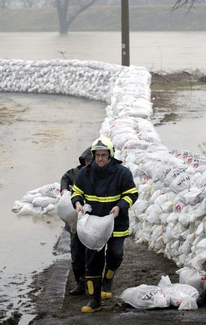 Hasiči zpevňují bariéru z pytlů s pískem na řece Odře v Ostravě-Koblově