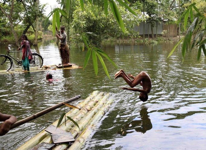 BANGLADESH-FLOODS/ Description: A boy jumps into floodwaters in Kurigram July 3, 2012. At least 100 people have died and hundreds of thousands of people are marooned as floods triggered by heavy rains spread across Bangladesh. REUTERS/Andrew Biraj (BANGLADESH - Tags: DISASTER ENVIRONMENT) Published: Čec. 3, 2012, 10:24 dop.