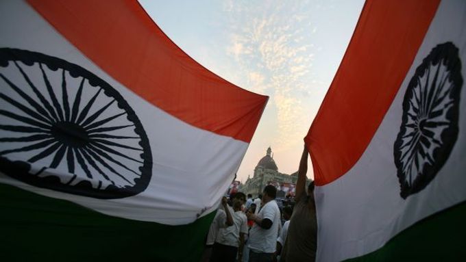 Lidé mávají indickými vlajkami před hotelem Tádž Mahal v Bombaji.