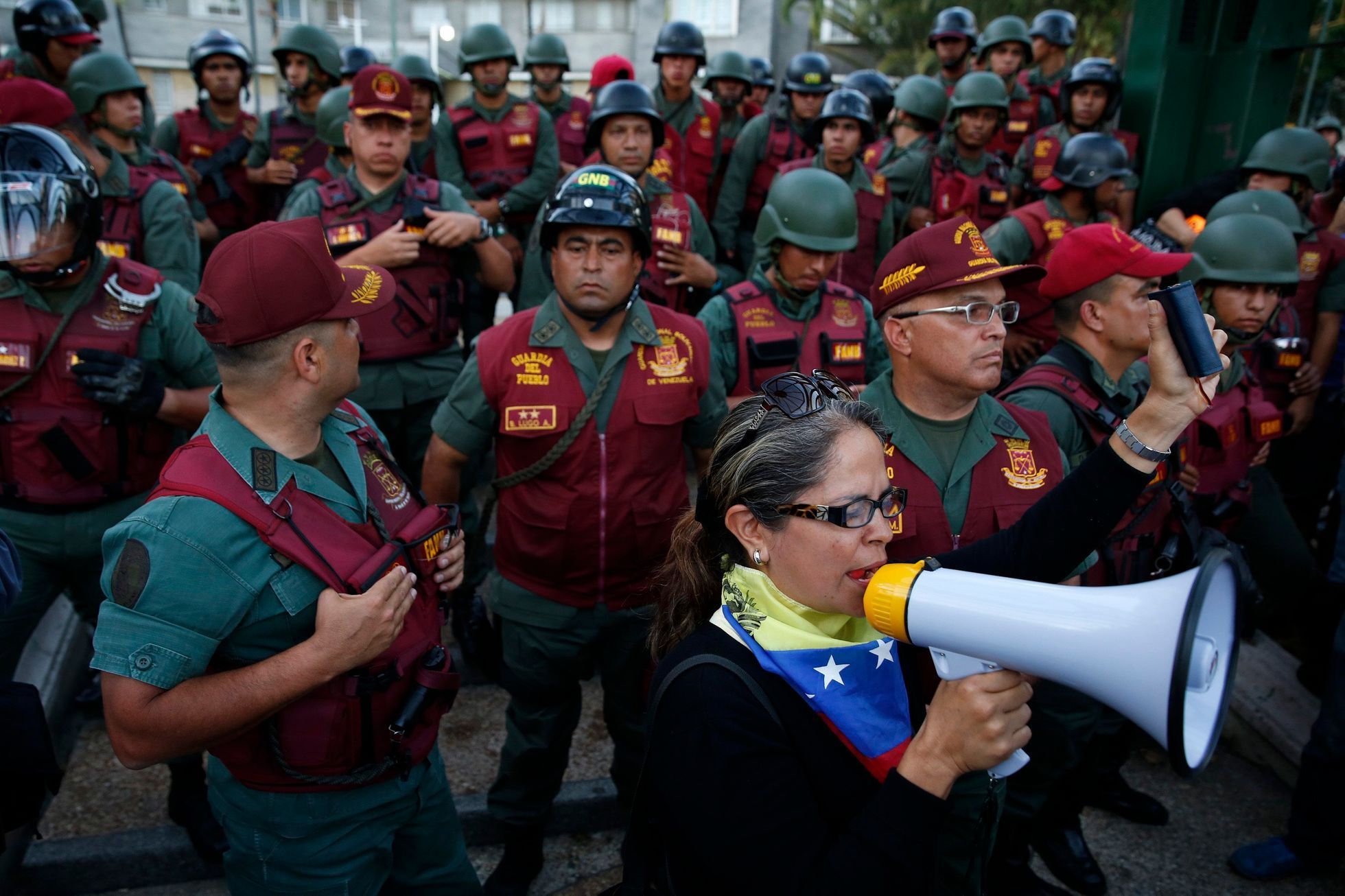 An opposition supporter speaks in front of National Guards during a protest in Caracas