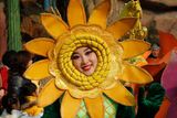 Dívka s maskou slunce na obličeji se účastnila oslav v jednom z pekingských zábavních parků.