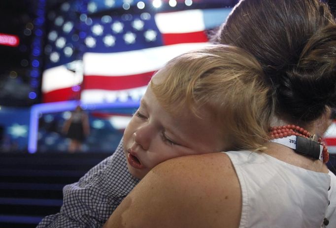 A convention-goer holds a child on the convention floor on the first day of the Democratic National Convention in Charlotte, North Carolina, September 4, 2012. REUTERS/Jessica Rinaldi (UNITED STATES - Tags: POLITICS ELECTIONS) Published: Zář. 4, 2012, 9:52 odp.