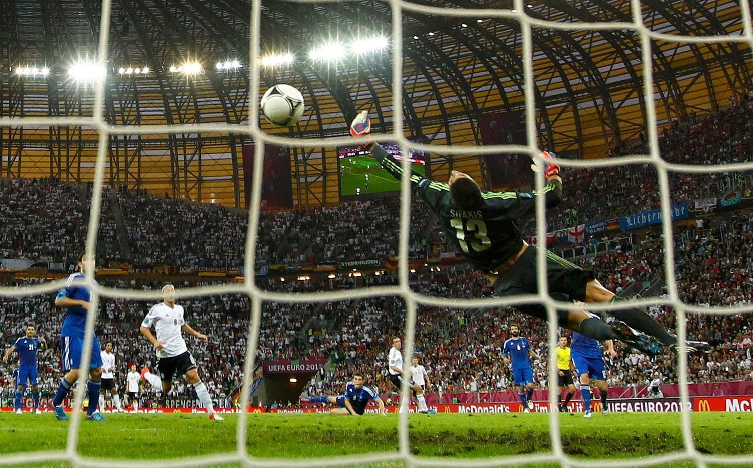 Philipp Lahm střílí gól za záda Michalise Sifakise během utkání Německo - Řecko ve čtvrtfinále Eura 2012