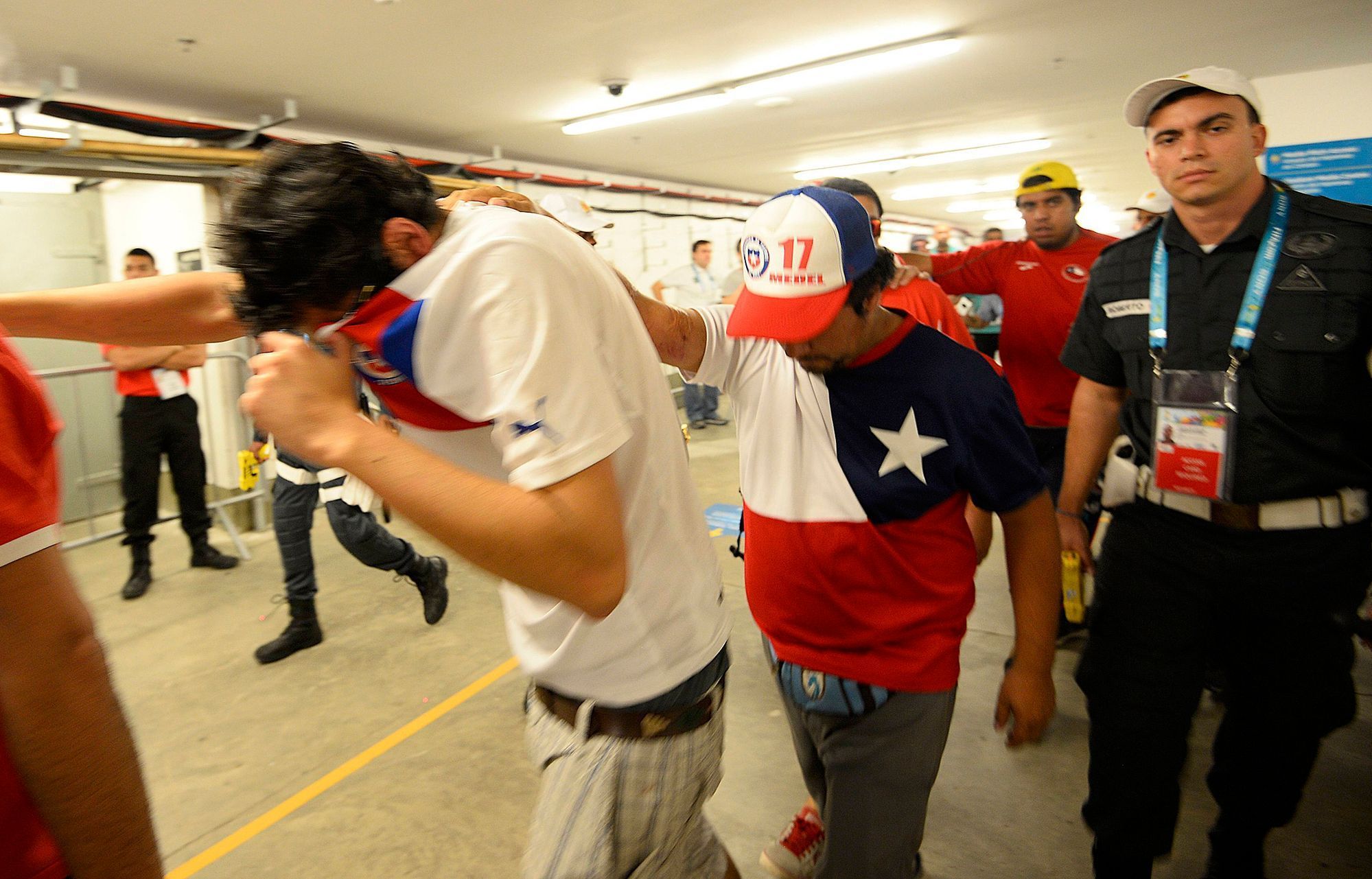 Chile fans are escorted by police after dozens of them crashed a gate to enter Maracana stadium