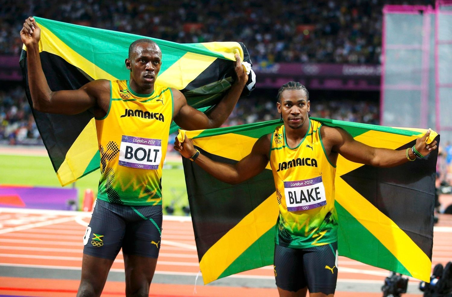 Jamajský sprinter Usain Bolt se raduje z vítězství ve finále na 100 metrů společně s druhým Yohanem Blakem během OH 2012 v Londýně.