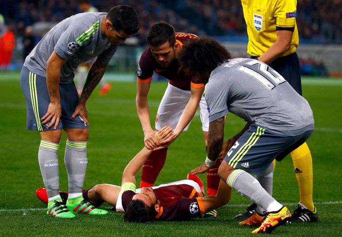 AS Roma's Alessandro Florenzi (C) lies on the pitch during the match against Real Madrid.