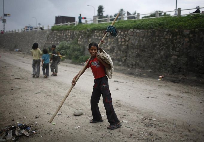 Drumpal Choudhary, 11, a street performer, walks on a street of Kathmandu August 15, 2012. Drumpal and his siblings, Shivani and Gchan, who came to Kathmandu from India 5 years ago, earn their living by performing tricks on the streets of Kathmandu. According to Drumpal, they earn around $10 a day by performing tricks, which is not enough to feed their 10-member family living together in a small hut without a proper toilet or any basic needs. REUTERS/Navesh Chitrakar (NEPAL - Tags: SOCIETY IMMIGRATION POVERTY) Published: Srp. 15, 2012, 4:27 odp.