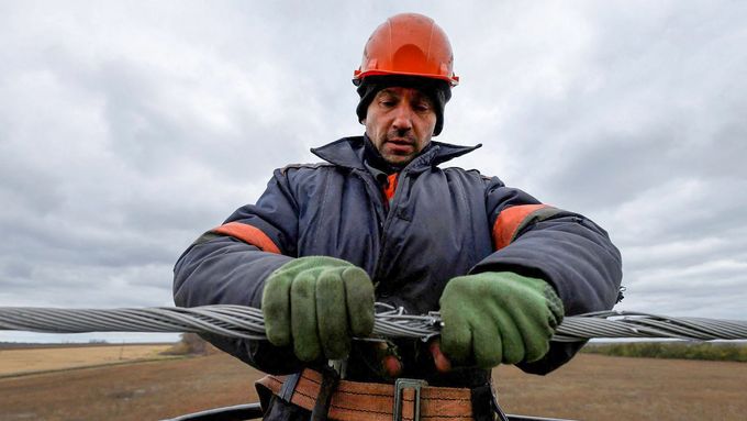 Elektrikář opravuje vedení nedaleko Charkova. Velká většina Ukrajiny už svítí, dodávky elektřiny jsou stabilní.