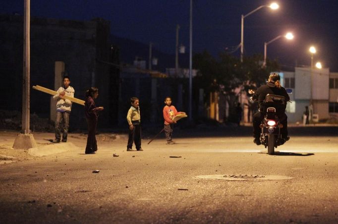 Catholic priest Adolfo Huerta (R), known as "Gofo", stops his motorcycle to ask for directions in Saltillo February 26, 2013. Ordained five years ago, Huerta is an unconventional priest who likes rock music, dyes the ends of his hair red, dresses in black, and enjoys riding his motorcycle. Huerta found God and priesthood while studying philosophy at the Pontifical University in Mexico City and working with HIV-positive patients and sex workers as a social activist. He says it is important to demystify faith and accept people's differences without judgment, and in his sermons he references rock songs, quotes books and tells jokes. Picture taken February 26, 2013. REUTERS/Daniel Becerril (MEXICO - Tags: RELIGION SOCIETY) ATTENTION EDITORS: PICTURE 16 OF 26 FOR PACKAGE 'CHURCH, FAITH AND ROCK'N ROLL' SEARCH 'PRIEST DANIEL' FOR ALL IMAGES Published: Bře. 15, 2013, 10:23 dop.