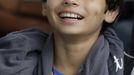 Gabriel Muniz, 11, wearing a Barcelona FC necklace, smiles in Campos dos Goytacazes, 274 kilometres (170 miles) northeast of Rio de Janeiro August 23, 2012. Despite being born with malformation of his feet, fourth grader Gabriel puts in hours into soccer everyday in his neighbourhood. He aspires to be a professional soccer player just like his idol Argentina's Lionel Messi of Barcelona FC. REUTERS/Ricardo Moraes (BRAZIL - Tags: SPORT SOCCER SOCIETY HEALTH) Published: Srp. 24, 2012, 2:25 dop.