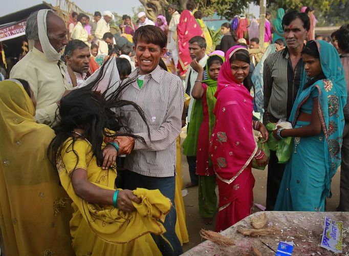 A man tries to hold a devotee who is believed to be possessed by evil spirits as she goes into a state of trance at Guru Deoji Maharaj temple during a ghost fair at Malajpur village in Betul district in the central Indian state of Madhya Pradesh January 27, 2013. People from across India come to this fair to be exorcised of �evil spirits�. They are usually brought by relatives and they are most often women. The exorcism involves running around the temple courtyard to make the 'ghost' weak then being beaten by a priest with a broom. Picture taken January 27, 2013. REUTERS/Danish Siddiqui (INDIA - Tags: SOCIETY RELIGION) ATTENTION EDITORS: PICTURE 2 OF 24 FOR PACKAGE 'INDIAN GHOSTBUSTERS' SEARCH 'INDIA GHOST' FOR ALL IMAGES Published: Úno. 5, 2013, 5:09 dop.