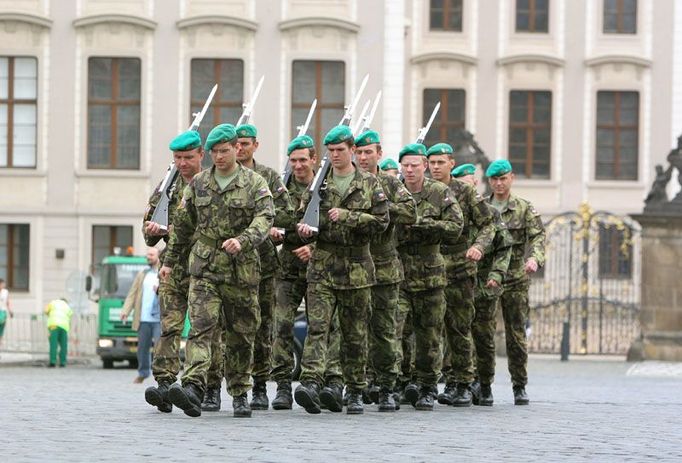 Vojáci Hradní stráže pochodují po Hradčanském náměstí.