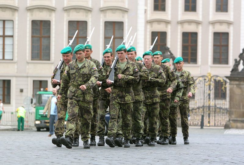 Vojáci Hradní stráže pochodují po Hradčanském náměstí