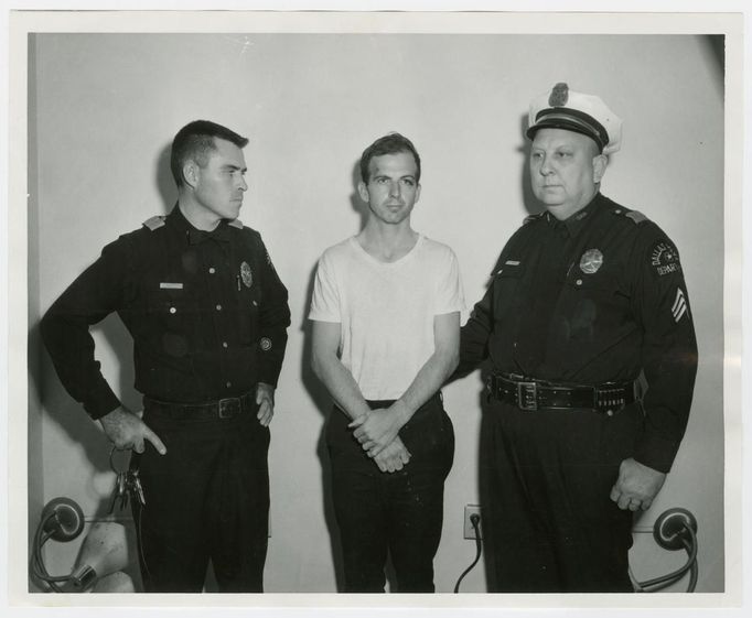 Lee Harvey Oswald, accused of assassinating former U.S. President John F. Kennedy, is pictured with Dallas police Sgt. Warren (R) and a fellow officer in Dallas, in this handout image taken on November 22, 1963