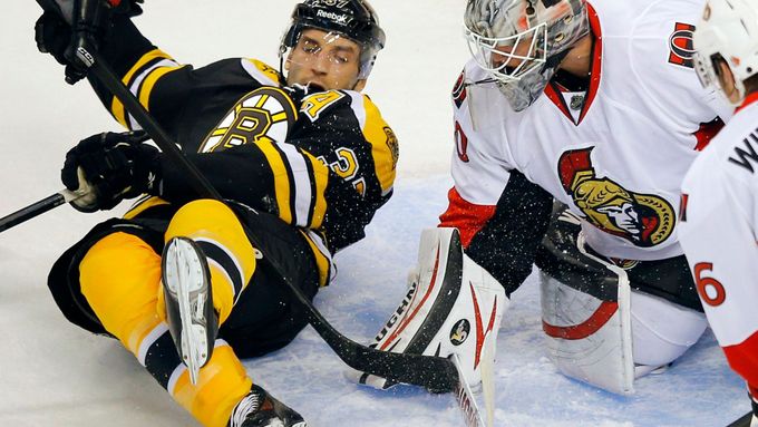 Robin Lehner zasahuje proti Patrici Bergeronovi v zápase Boston - Ottawa