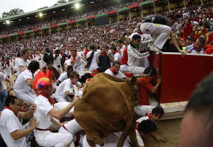 A wild cow leaps over a group of revellers following the third day of the running of the bulls at the bullring during the San Fermin festival in Pamplona July 9, 2012. Various runners suffered light injuries in a run that lasted two minutes and twenty-eight seconds, according to the Navarran government press office. REUTERS/Joseba Etxaburu (SPAIN - Tags: ANIMALS SOCIETY) Published: Čec. 9, 2012, 10:05 dop.