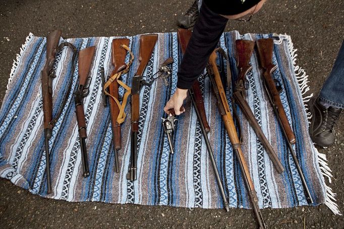 John Laigaie III, a retired Army master sergeant, lays out guns he and two other friends purchased on the periphery of the Seattle Police Department's gun buyback event in Seattle on Saturday, Jan. 26, 2013. Many independent gun buyers and sellers operated on the periphery of the official buyback, offering Amazon gift cards in exchange for firearms. (AP Photo/The Seattle Times, Bettina Hansen) MAGS OUT; NO SALES; SEATTLEPI.COM OUT; MANDATORY CREDIT; TV OUT; USA TODAY OUT