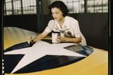Irma Lee McElroyová před válkou pracovala jako úřednice v kanceláři. Na snímku maluje výsostné znaky na křídlo letadla (1942).