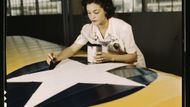 Irma Lee McElroyová před válkou pracovala jako úřednice v kanceláři. Na snímku maluje výsostné znaky na křídlo letadla (1942).