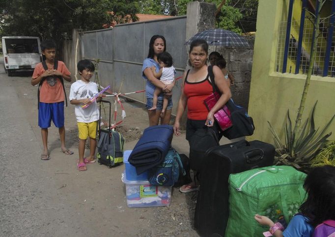 Residents wait for a truck to transport them into an evacuation center as local officials ordered enforced evacuation ahead of Typhoon Bopha in Cagayan de Oro City, southern Philippines December 3, 2012. Philippine President Benigno Aquino told people on Monday to take storm warnings seriously as authorities evacuated thousands of residents of coastal and mountain regions hours before the biggest typhoon this year was due to hit. REUTERS/Stringer (PHILIPPINES - Tags: POLITICS ENVIRONMENT SOCIETY DISASTER) Published: Pro. 3, 2012, 12:31 odp.