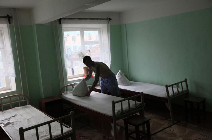 Inmate Boris Kovalyov, 32, makes a bed in sleeping quarters at a high-security male prison camp outside Russia's Siberian city of Krasnoyarsk April 30, 2013. Kovalyov was sentenced to eight years in a high-security prison camp for drug trafficking, but was released two and a half years early, on May 10, 2013, for good behaviour and participation in sports and cultural activities. Before being released, Kovalyov had been serving part of his sentence in high-security male prison camp number 5, intended to house male inmates who have multiple convictions for serious crimes. Prisoners at the facility work in wood and metal processing shops, manufacture furniture, sew clothes and do other kinds of work. They can also take part in educational, sport and cultural programs. Picture taken April 30, 2013. REUTERS/Ilya Naymushin (RUSSIA - Tags: CRIME LAW SOCIETY) ATTENTION EDITORS: PICTURE 25 OF 29 FOR PACKAGE 'INSIDE SIBERIA'S PRISONS' SEARCH 'ILYA PRISON' FOR ALL IMAGES Published: Čer. 19, 2013, 10:05 dop.