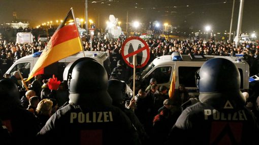 Policejní auta oddělují účastníky pondělních demonstrací odpůrců a příznivců Pegidy v Drážďanech.