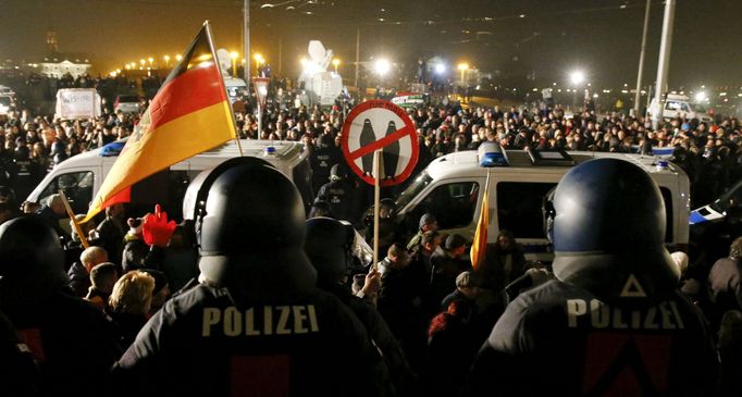 Policejní auta oddělují účastníky pondělních demonstrací odpůrců a příznivců Pegidy v Drážďanech.