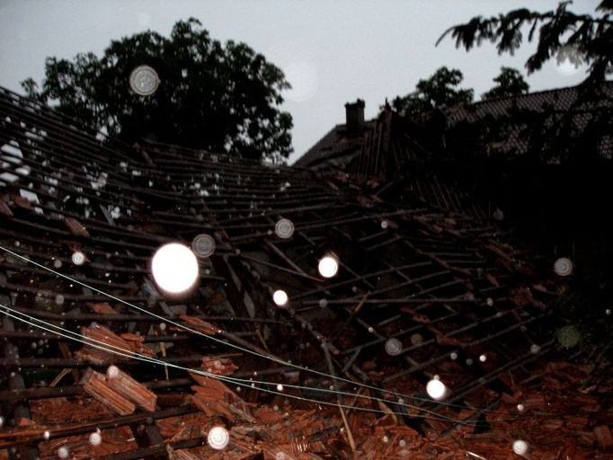 Záběr ze středečního večera v Domašíně na Rychnovsku, kde strom spadl na střechu stodoly.