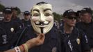 A demonstrator holds a Guy Fawkes mask in front of a line of police officers blocking a protest march near the site of the Democratic National Convention in Charlotte, North Carolina on September 4, 2012. President Barack Obama will be nominated as the Democratic candidate at the convention, along with Vice President Joe Biden as his running mate, for November's U.S. presidential election. REUTERS/Adrees Latif (UNITED STATES - Tags: POLITICS ELECTIONS CIVIL UNREST TPX IMAGES OF THE DAY) Published: Zář. 4, 2012, 10:05 odp.