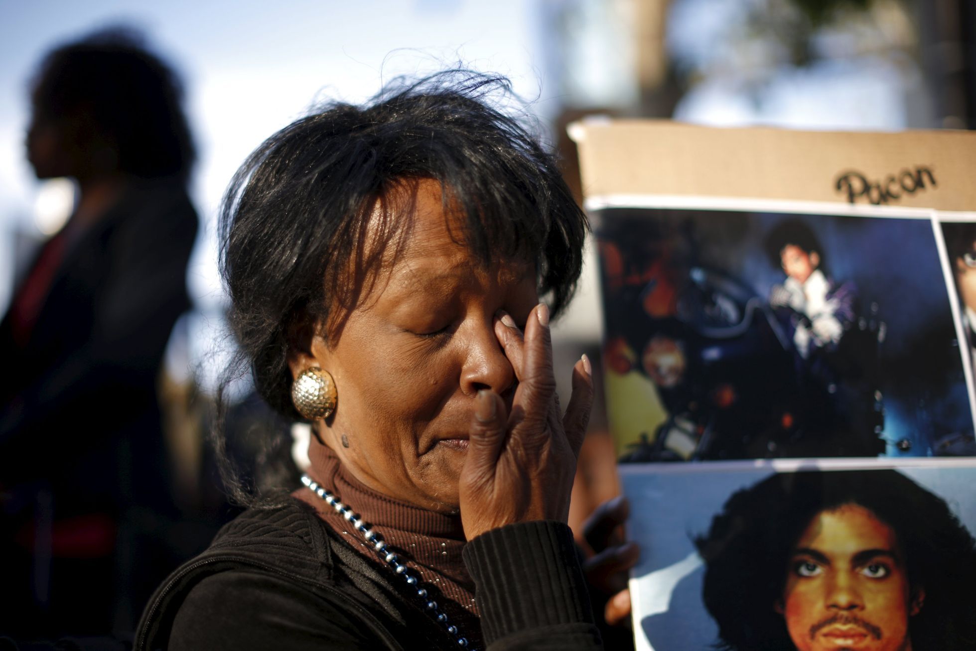 Lorraine Womble wipes her eye at a vigil to celebrate the life and music of deceased musician Prince in Los Angeles