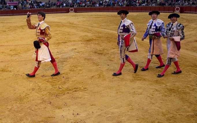 Spanish matador Fernandez celebrates next to his assistants after wining the ear of a bull during a bullfight in Seville