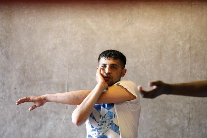 Unemployed Belgian Mohamed Sammar stretches as he takes part in a "Fit for a job" boxing class in Brussels June 14, 2013. Sammar, 27, has been looking for a job in the construction sector for 2 years. "Fit for a job" is the initiative of former Belgian boxing champion Bea Diallo, whose goal was to restore the confidence of unemployed people and help them find a job through their participation in sports. Picture taken June 14, 2013. REUTERS/Francois Lenoir (BELGIUM - Tags: SPORT BOXING SOCIETY BUSINESS EMPLOYMENT) Published: Čec. 5, 2013, 3:59 odp.