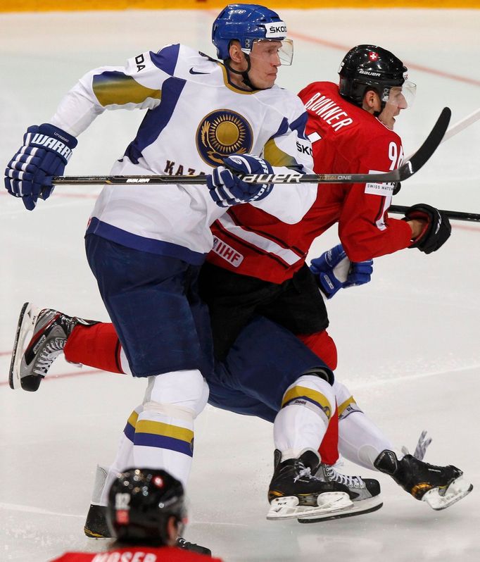 Alexej Litviněnko a Damien Brunner bojují o puk v utkání MS v hokeji 2012 Švýcarsko - Kazachstán.