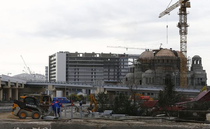 A church is built next to the Olympic stadium (L) for the Sochi 2014 Winter Olympics, at the seafront within the perimeters of the Olympic Park in Adler, near Sochi February 18, 2013. Although many complexes and venues in the Black Sea resort of Sochi mostly resemble building sites that are still under construction, there is nothing to suggest any concern over readiness. Construction will be completed by August 2013 according to organizers. The Sochi 2014 Winter Olympics opens on February 7, 2014. REUTERS/Kai Pfaffenbach (RUSSIA - Tags: BUSINESS CONSTRUCTION CITYSCAPE ENVIRONMENT SPORT OLYMPICS RELIGION) Published: Úno. 18, 2013, 7:44 odp.