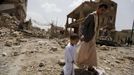 A man and a boy walk at a site hit by a Saudi-led air strike in Yemen's capital Sanaa July 3, 2015. Warplanes from a Saudi-led coalition bombed targets in the Yemeni capi