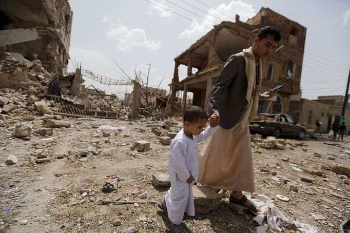 A man and a boy walk at a site hit by a Saudi-led air strike in Yemen's capital Sanaa July 3, 2015. Warplanes from a Saudi-led coalition bombed targets in the Yemeni capi