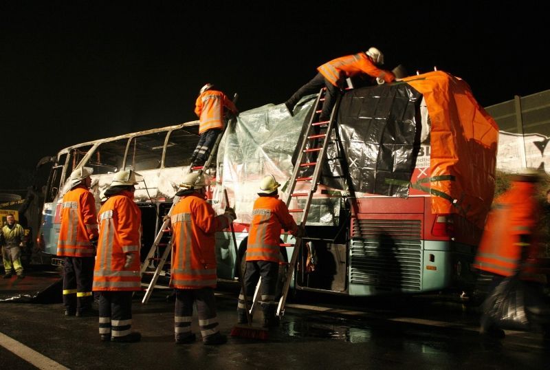 Hasiči prohlížejí vrak autobusu, který shořel u německého Hannoveru