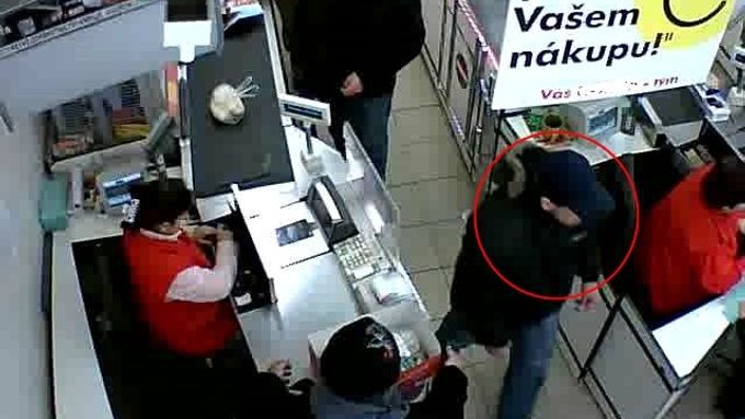 Zloděj v kšiltovce odchází z prodejny i s penězi.