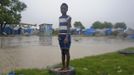 A Haitian girl stands on a tyre in a tent camp for people affected by the January 2010 earthquake, next to a street flooded by Tropical Storm Isaac in an area outside of Port-au-Prince August 25, 2012. Tropical Storm Isaac emerged over warm Caribbean waters on Saturday slightly weaker but ready to regroup after dumping torrential rains on Haiti, where thousands of people remain homeless more than two years after a devastating earthquake. REUTERS/Swoan Parker (HAITI - Tags: DISASTER ENVIRONMENT) Published: Srp. 25, 2012, 10:57 odp.