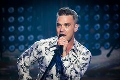 Recenze: Osobní texty, nadsázka a silné melodie dělají z novinky Robbieho Williamse vynikající album