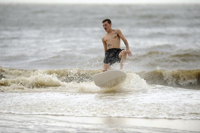 Jonathan McGill skimboards along the coast as Hurricane Isaac approaches Gulfport, Mississippi, August 28, 2012. REUTERS/Michael Spooneybarger (UNITED STATES - Tags: ENVIRONMENT DISASTER) Published: Srp. 28, 2012, 5:44 odp.