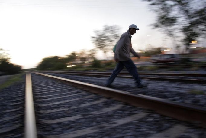 Edgar crosses the train tracks next to a train carriage he calls home in Cadereyta on the outskirts of Monterrey August 8, 2012. Edgar, his eight other family members and their pets have been living in the abandoned carriage next to a train track for the last 15 years. Edgar's parents moved from Tamaulipas to Cadereyta after Edgar's brother was killed on the street by a stray bullet. The family moved into the carriage, which was empty after having been occupied by a vagabond, after living for the first five years in a rented room after arriving in Cadereyta. Picture taken August 8, 2012. REUTERS/Daniel Becerril (MEXICO - Tags: SOCIETY) Published: Srp. 11, 2012, 2:51 dop.