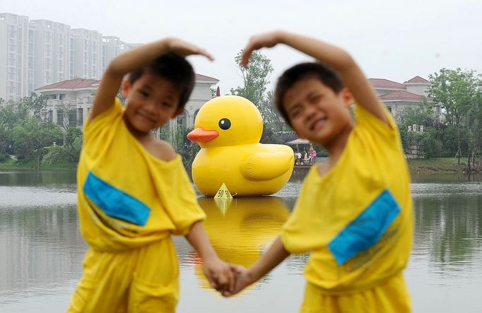 WUHAN, CHINA - JUNE 01: (CHINA OUT) Visitors look at a giant rubber duck on June 1, 2013 in Wuhan, Hubei province of China. The six-meter tall rubber duck is on shown in the city beginning on June 1 to celebrate the International Children's Day. The duck is a copy of Dutch artist Florentijn Hofman's original giant 16.5-m tall 'Rubber Duck', which was on shown in May 2013 in Hong Kong.