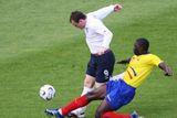 Ekvádorec Geovanny Espinoza atakuje Wayna Rooneyho z Anglie (v bílém).