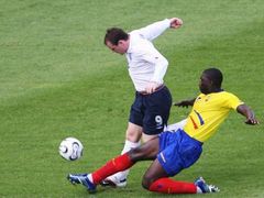 Ekvádorec Geovanny Espinoza atakuje Wayna Rooneyho z Anglie (v bílém).