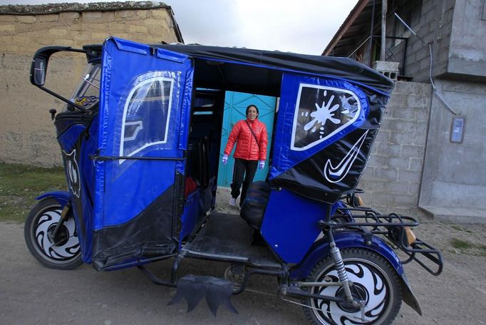 Marathon runner Gladys Tejeda, the first Peruvian athlete who qualified for the 2012 London Olympic Games, looks on before entering a three-wheeled taxi vehicle or "mototaxi" in the Andean province of Junin May 15, 2012. A private company will take Gladys' mother Marcelina Pucuhuaranga, 69, to London as part of the "Thank you Mom" program. For Pucuhuaranga, who received her first passport, it will be the first time travelling out of Peru. The program will take about 120 mothers of different athletes around the world to attend the games. Tejeda, the youngest of nine children, returned to her hometown to visit her mother and to focus on training where she will run more than 20 km every day in the highlands (over 4,105 meters above sea level). Picture taken May 15, 2012. REUTERS/Pilar Olivares (PERU - Tags: SPORT ATHLETICS OLYMPICS) Published: Kvě. 17, 2012, 6:34 odp.