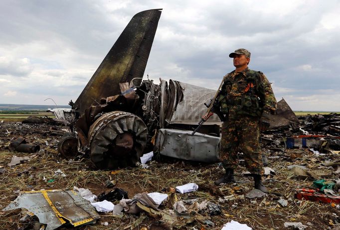 Ozbrojená stráž u sestřeleného letadla Il-76 ukrajinské armády. Trosky hlídá separatista.